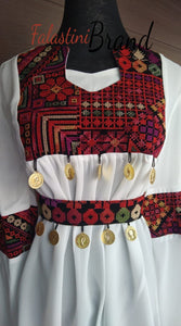 White elegant blouse with colorful embroidery and stylish coins